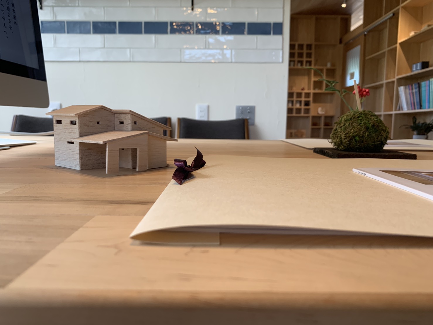 打ち合わせ風景、お家の模型とファイルの乗った机