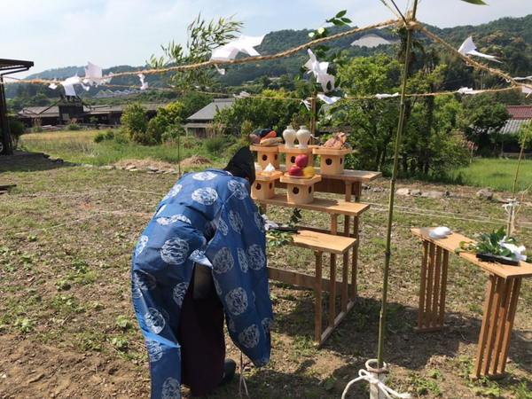 岡崎市エリアで注文住宅を手掛ける共感住宅ray-outの地鎮祭の様子。お供え物をまえに神主さんが頭を下げています。