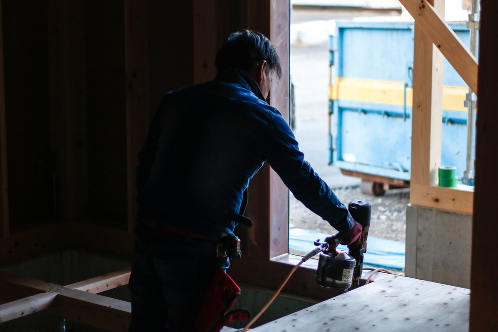 豊川市で注文住宅をつくる大工さん。床の合板を切って貼っているところ