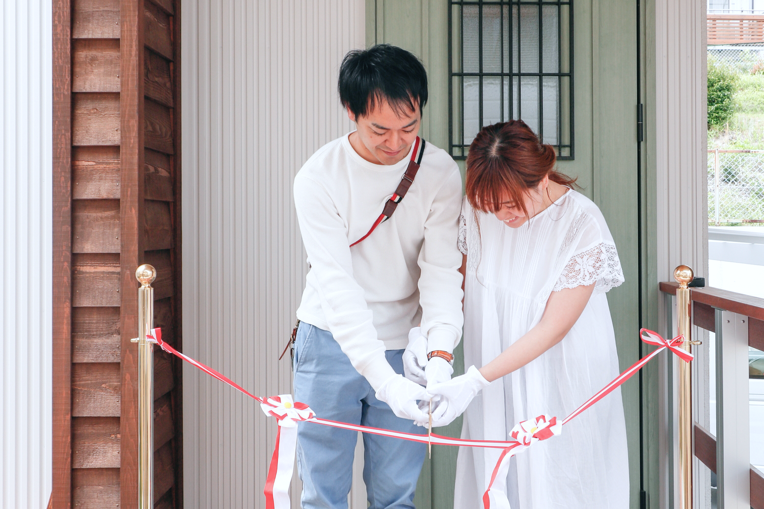 可愛い注文住宅の完成記念にテープカットをするオーナーご夫婦