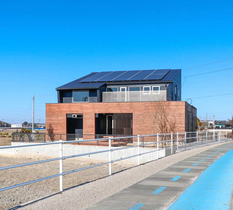 開けた土地に建つ黒と木の外観