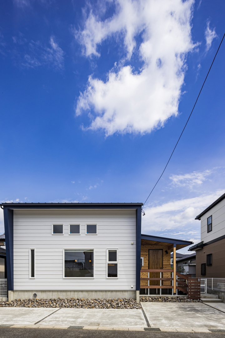 白と紺の北欧風な部分と天然木の山小屋風がバランスよくまとまった外観