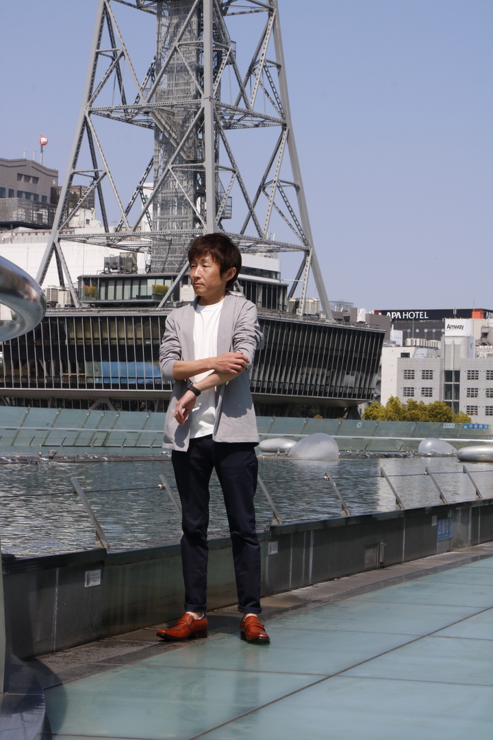 名古屋のテレビ塔のそばでポーズをとる共感住宅レイアウト社長の山本健