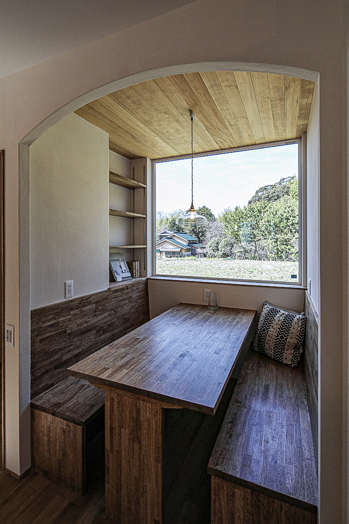アールの垂れ壁の開口に、箱型のベンチ、造り付けのダイニングスペース。