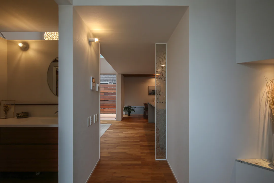 玄関の廊下からLDKを見た眺め。正面奥には間仕切りの無いダイニングキッチンが見える。