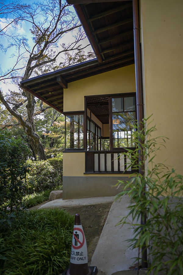 聴竹居の外観。サンドベージュの塗り壁に、ゆったりとした確度を持った屋根がかかる