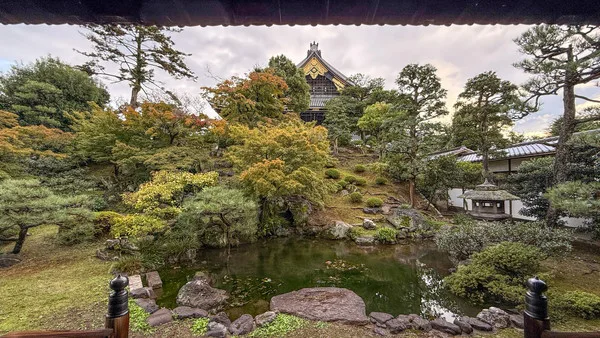 東本願寺の庭。手前に池があり岩が置かれている。奥には建物の屋根が見える
