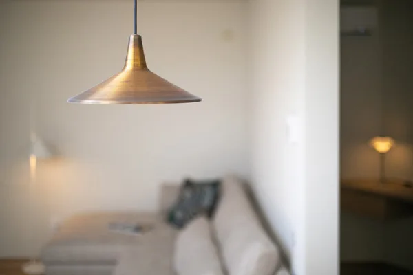 リビングルームを照らす、真鍮色のペンダントライト。上質な素材感が空間のアクセントに。