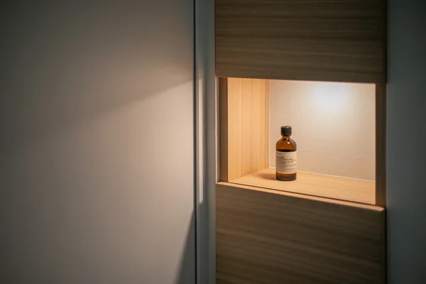 木製の収納棚にAesopの化粧水がディスプレイされている。細部までこだわったインテリア。