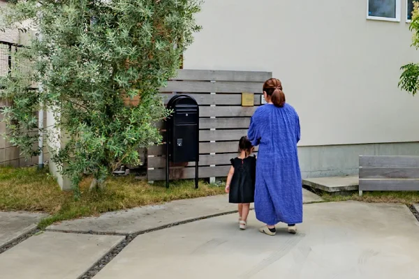 家の駐車場を母親と子供が歩いている