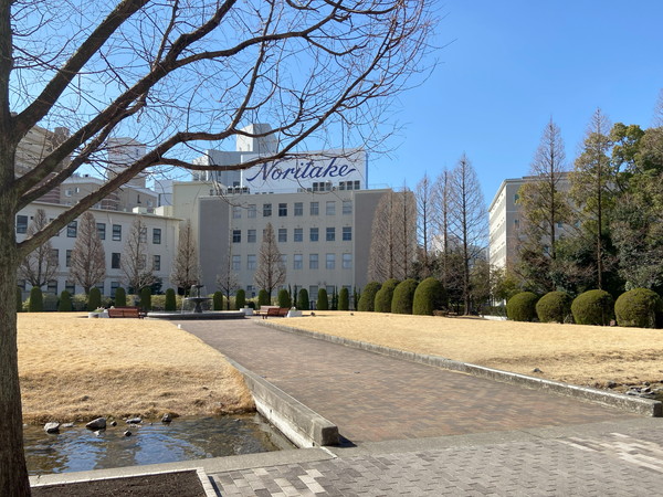 真ん中に道があり、左右に芝部の広場がある。奥にはビルが見える