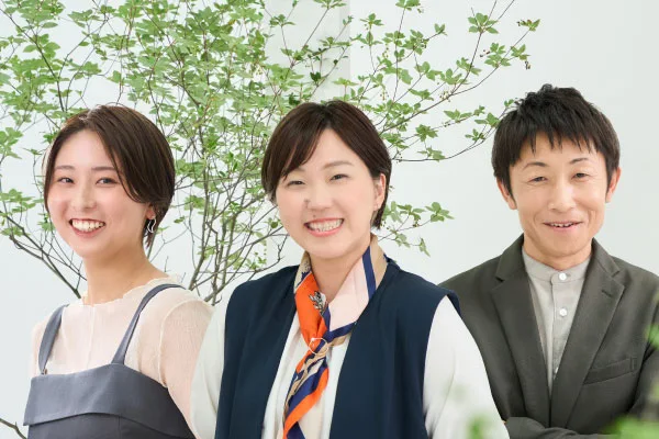 3人の笑顔のバストアップ写真。左2人が女性、右端が男性