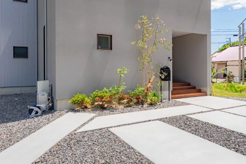 土地の上にグレーの家が建っている