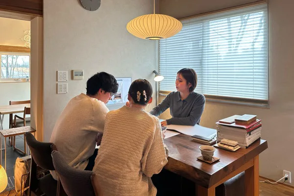 家づくりについて説明する担当者と話を聞く夫婦