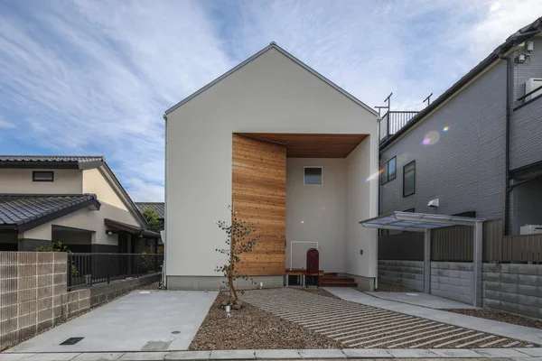 平坦できれいな区画に建つ家。三角屋根の白い家。