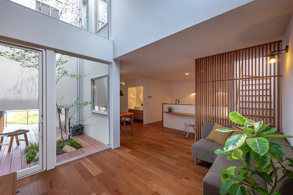 中庭を囲むLDK。中庭の床にはウッドデッキがあり、植物が植わっている。