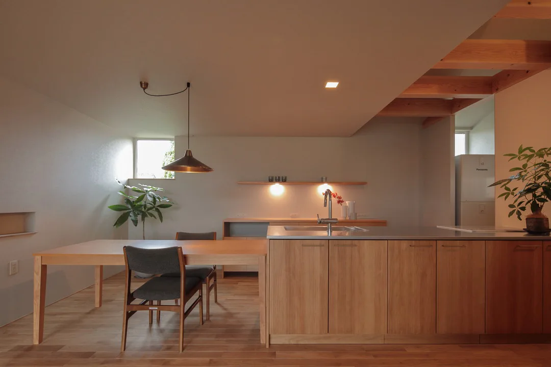 木の温もりに包まれたwoodoneのアイランドキッチンと、横並びになっているダイニングテーブル。