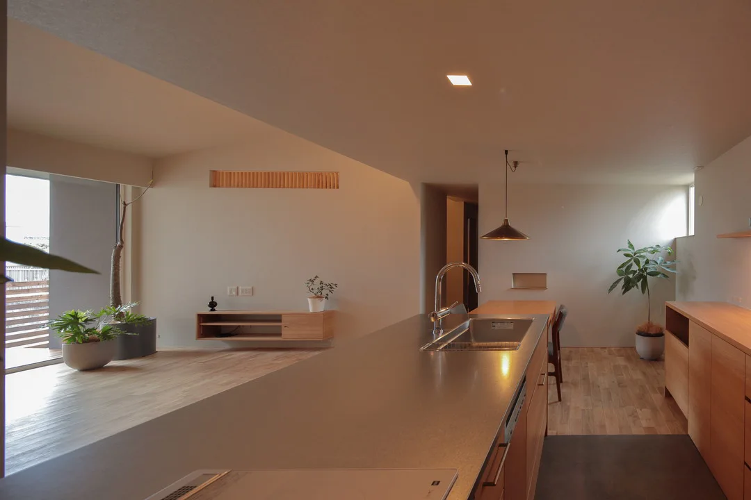 料理をしながらリビング全体と外の景色を見渡せる、オープンな間取りのLDK。壁のクロスは明るさを抑えたグレー