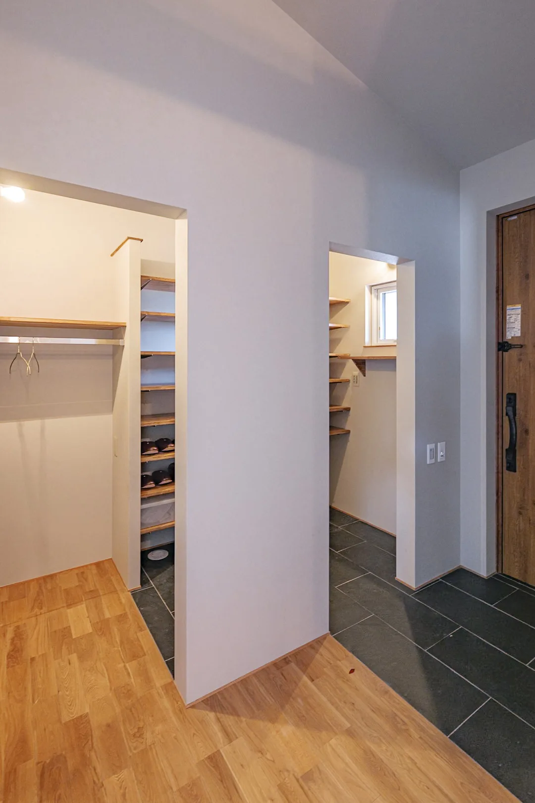 土間続きの広々としたシューズクロークと、オーク材のフローリングが続く室内への動線。
