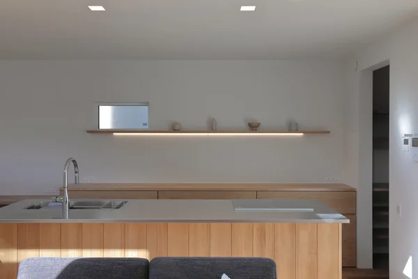 白い壁に、ミディアムブラウンの木をふんだんに使ったキッチン。