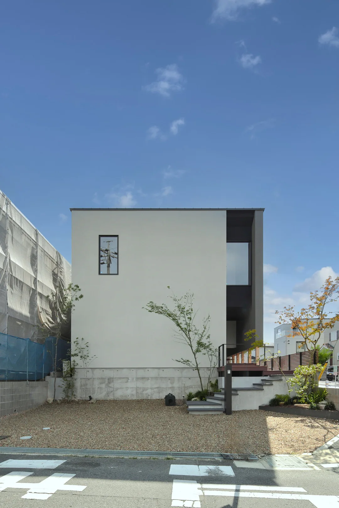 青空の下、白い外壁と黒いアクセントカラーが際立つ2階建ての住宅全景