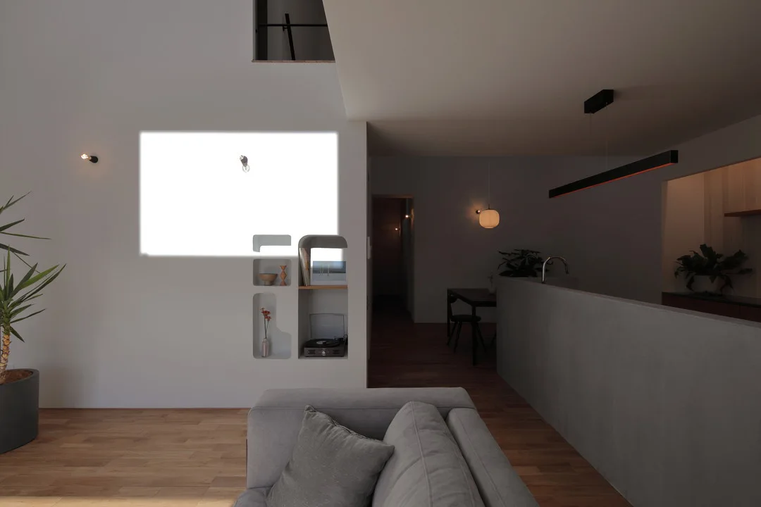 壁面に四角く強い日差しが差し込む、明暗のコントラストが美しいリビングの風景