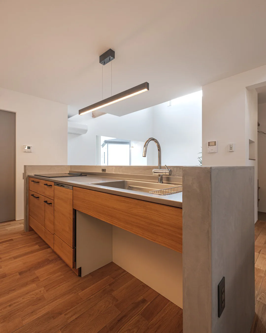 ステンレス天板と木目調のキャビネットが組み合わされた、機能的なキッチンの内側